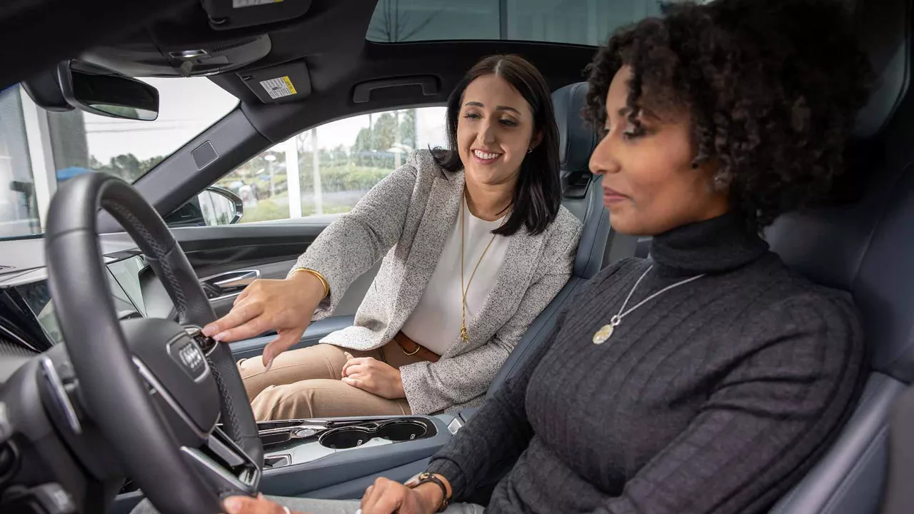 An Audi dealer showing a customer the interior of an Audi vehicle.