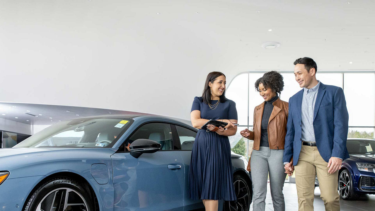 Audi Sale Specialist walking through the showroom with a couple.