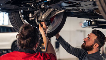 Service technician servicing wheel alignment.