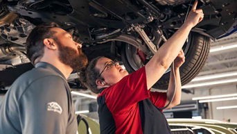 Service technician servicing a vehicle.