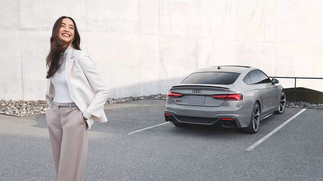 Woman standing behind Audi RS5