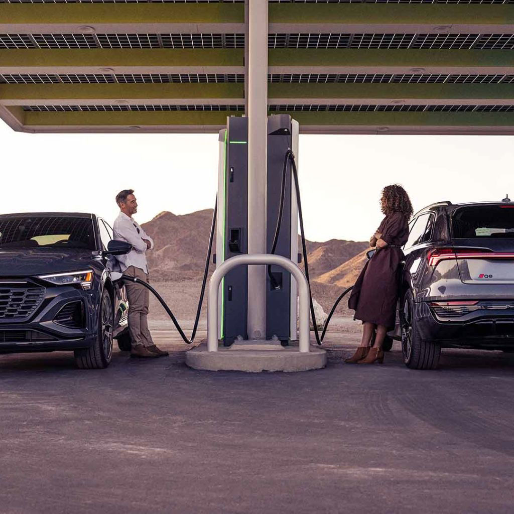 Two people chatting with each other across the charging station.