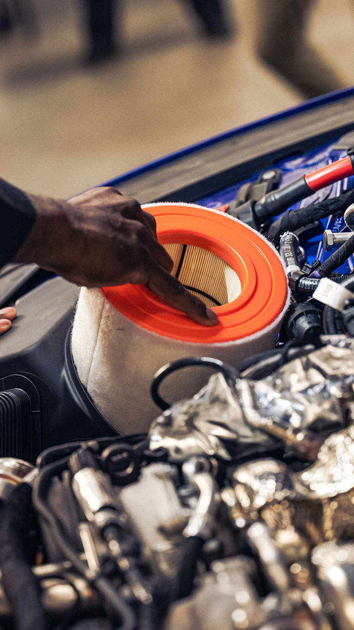 Audi service technician replacing a vehicle part