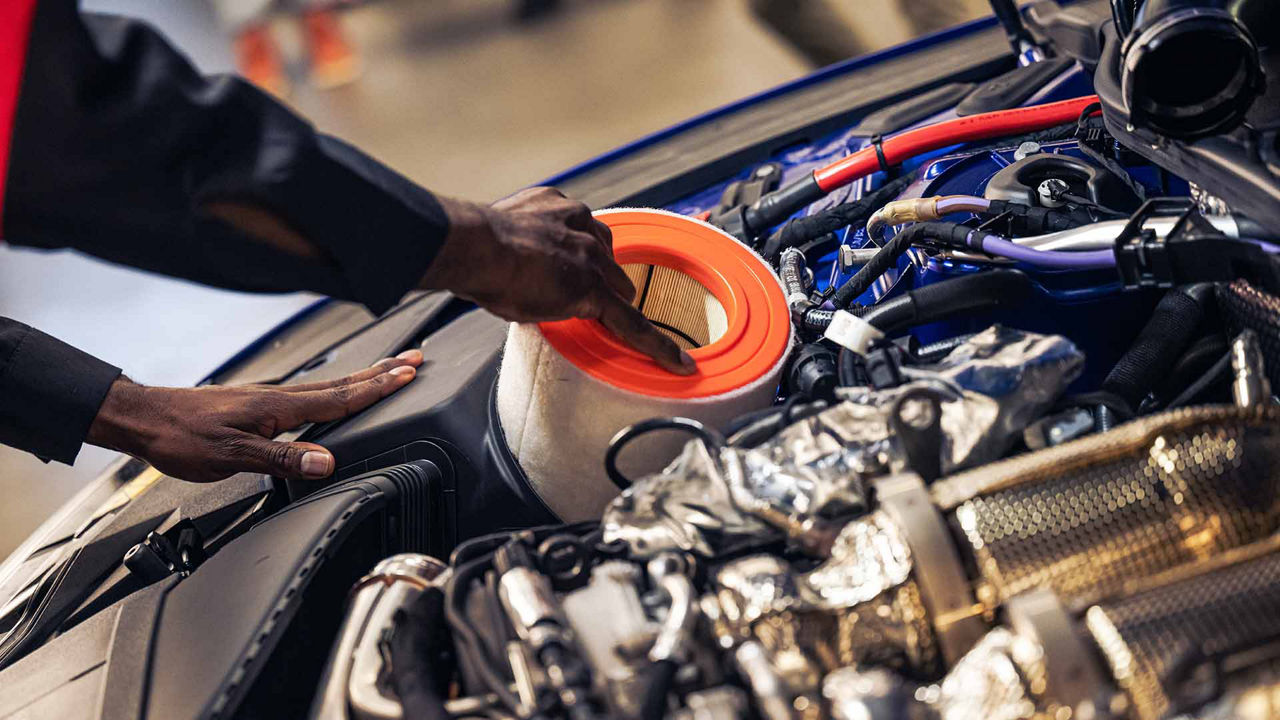 Audi service technician servicing a vehicle.