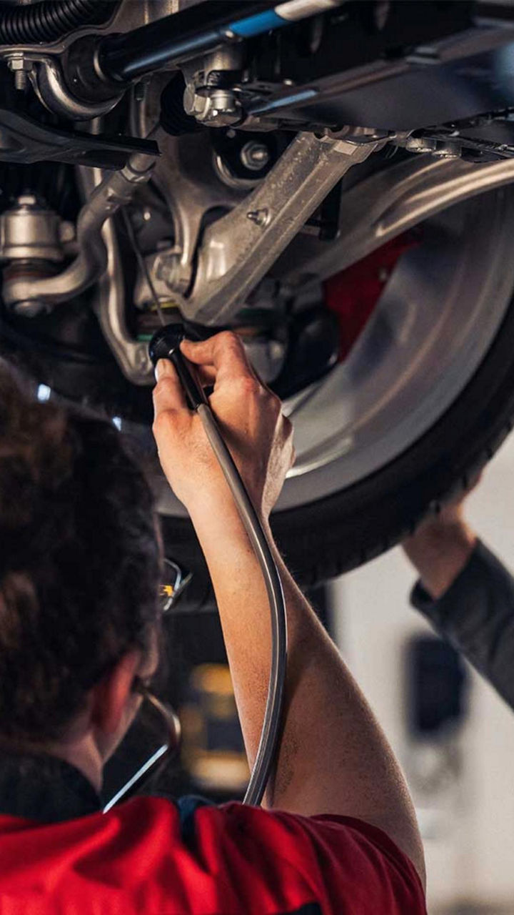 Service technician servicing a tire with another technician