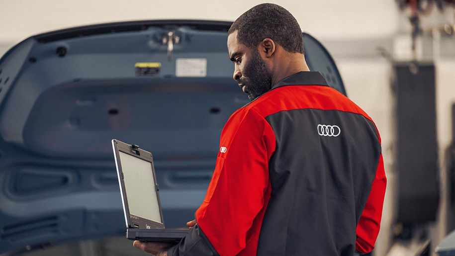 Audi service technician working on an Audi vehicle.