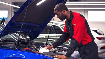 Technician inspecting the front of a vehicle. Special offer.  