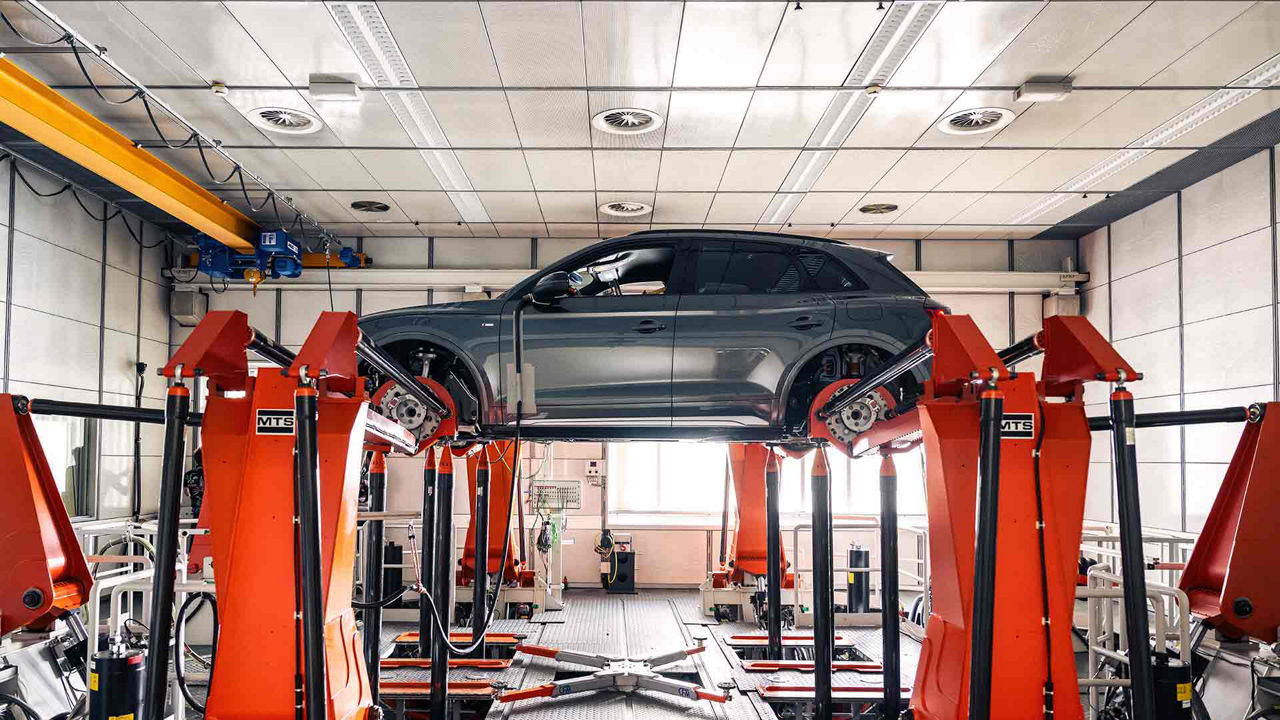 Side view of the chassis of an Audi vehicle in a factory. 