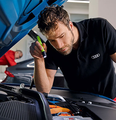 An Audi Technician inspecting a vehicle.